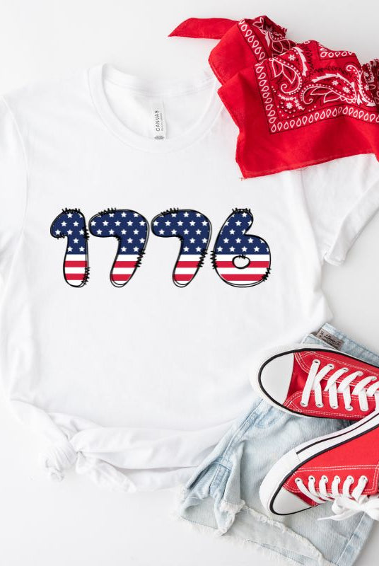 Close-up image of a USA July 4th graphic tee with the number '1776' spelled out in American flag inspired numbers on the front. This patriotic tee is perfect for celebrating Independence Day in style and showing off your love for America on a white graphic tee.