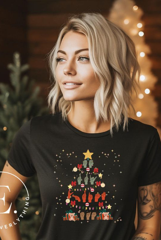 Add festive cheer with this ASL Merry Christmas t-shirt. The hands skillfully shape the words 'Merry Christmas' in American Sign Language, forming a beautiful Christmas tree design on a black colored shirt.