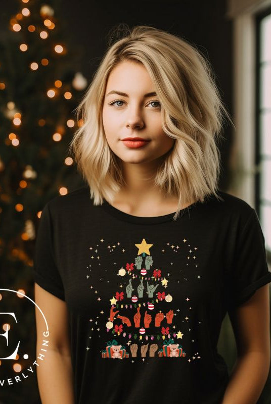 Add festive cheer with this ASL Merry Christmas t-shirt. The hands skillfully shape the words 'Merry Christmas' in American Sign Language, forming a beautiful Christmas tree design on a black colored shirt. 