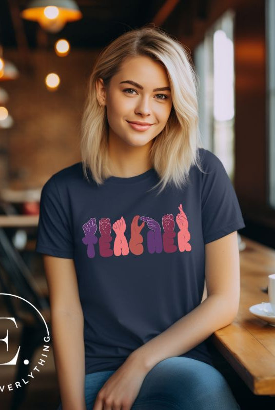 Let's celebrate our educators with this unique ASL teacher t-shirt. The word "teacher" is spelled out in American Sign Language using expertly crafted hands, highlighting their vital role in shaping our society. ASL teacher on a navy colored shirt.