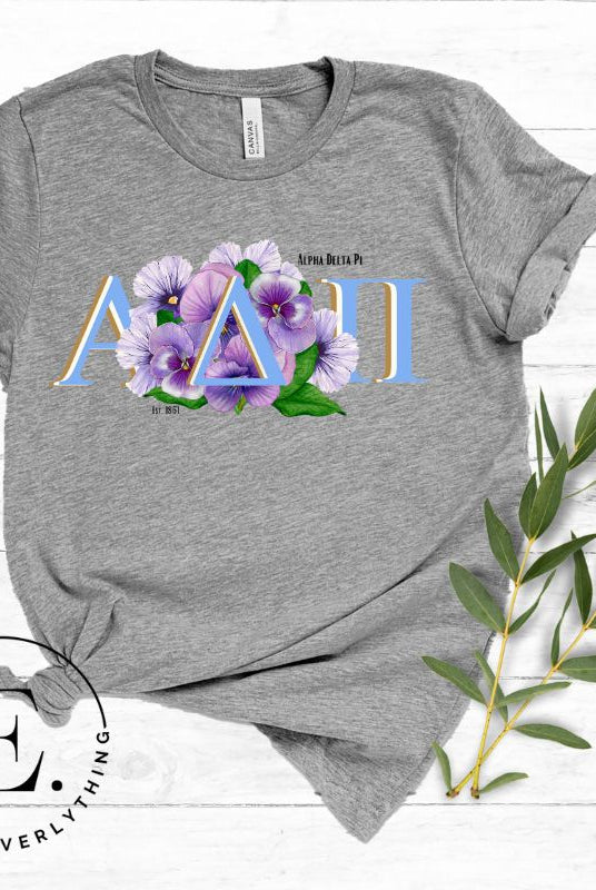 Show your Alpha Delta Pi pride with our stylish t-shirt featuring the sorority letters and the iconic violet, their symbolic flower on a grey shirt. 
