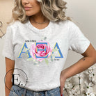 Show your Alpha Xi Delta pride with our stylish t-shirt featuring the sorority's letters and iconic pink rose on a grey shirt. 