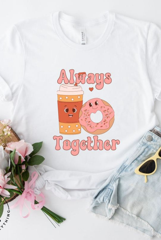 Celebrate love with our adorable Valentine's Day graphic tee! Featuring a smiling coffee cup and a cheerful donut holding hands, on a white shirt. 