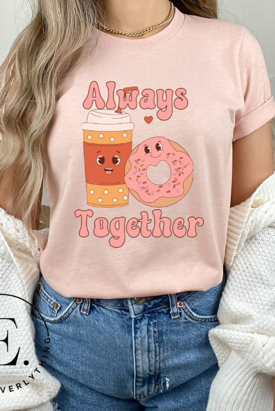 Celebrate love with our adorable Valentine's Day graphic tee! Featuring a smiling coffee cup and a cheerful donut holding hands, on a soft pink shirt. 