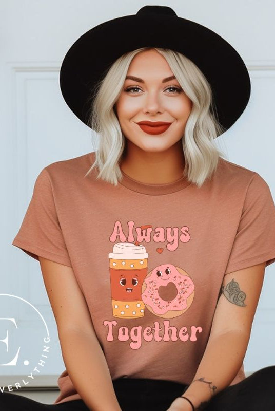 Celebrate love with our adorable Valentine's Day graphic tee! Featuring a smiling coffee cup and a cheerful donut holding hands, on a mauve shirt. 
