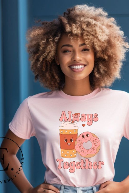 Celebrate love with our adorable Valentine's Day graphic tee! Featuring a smiling coffee cup and a cheerful donut holding hands, on a pink shirt. 