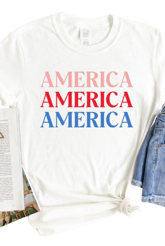 Close-up image of a USA July 4th graphic tee with the word 'America' repeated three times in bold lettering on the front. This festive tee is perfect for celebrating Independence Day in style and showing off your patriotic spirit on white graphic tee. 
