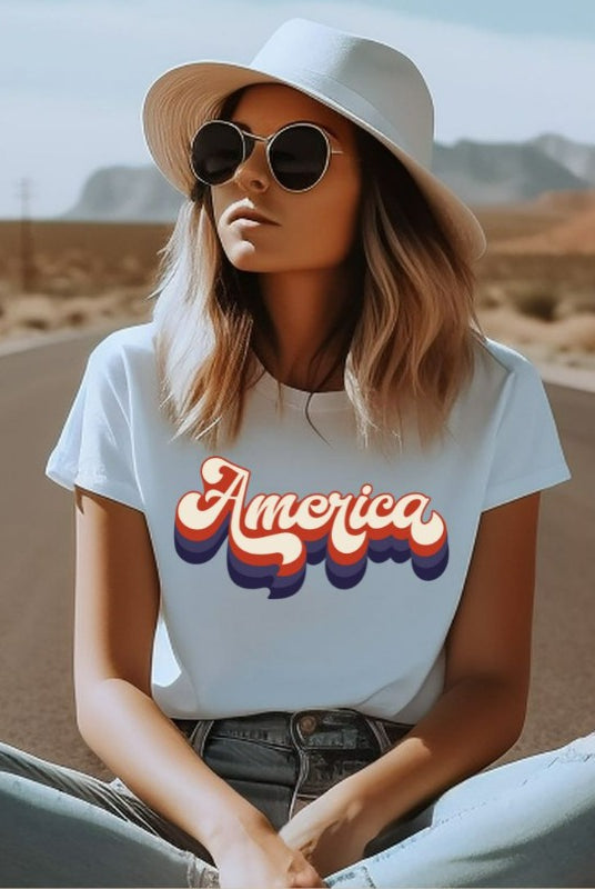 Close-up image of a USA July 4th graphic tee with the word 'America' spelled out in funky retro lettering on the front. This vintage-inspired tee is perfect for adding a fun and nostalgic touch to your Independence Day celebrations on a white graphic tee.