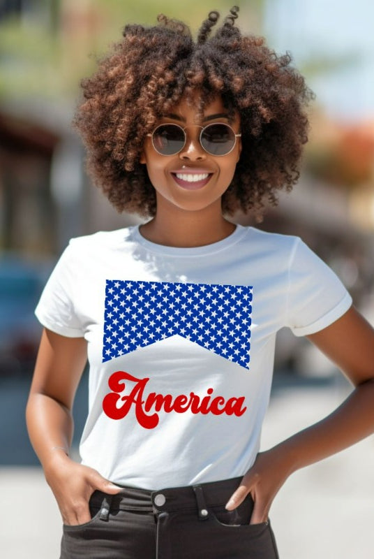 Close-up image of a USA July 4th graphic tee with the word 'America' spelled out in retro lettering on the front. The lettering is filled with iconic American flag stars, adding a patriotic touch to the design on white graphic tee. 