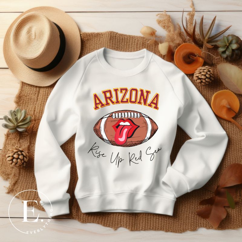 Support the Arizona Cardinals in style with our exclusive sweatshirt featuring the team's name and rallying slogan, "Rise Up Red Sea." On a white sweatshirt. 