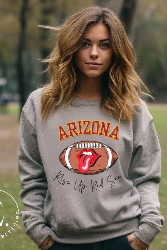Support the Arizona Cardinals in style with our exclusive sweatshirt featuring the team's name and rallying slogan, "Rise Up Red Sea." On a grey sweatshirt. 