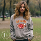 Support the Arizona Cardinals in style with our exclusive sweatshirt featuring the team's name and rallying slogan, "Rise Up Red Sea." On a grey sweatshirt. 