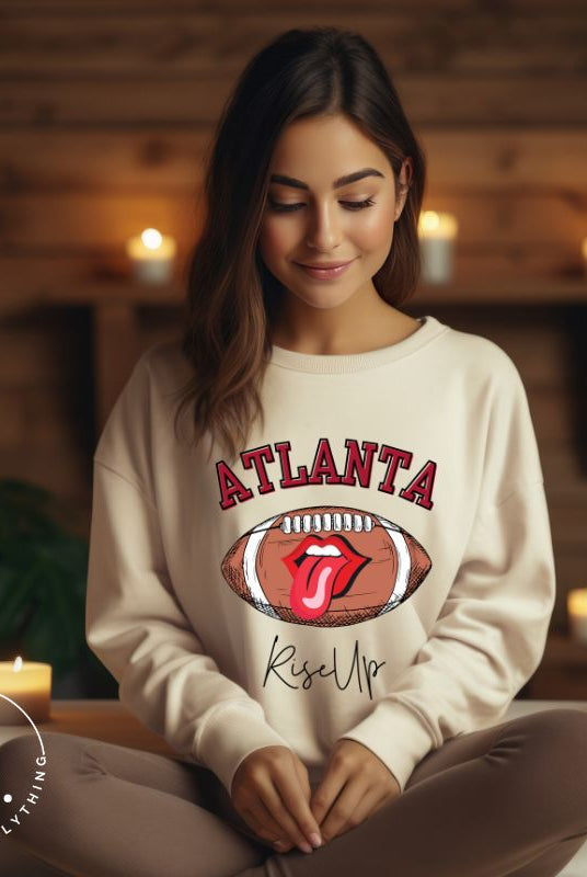 Show your Atlanta Falcons pride with our cozy and warm sweatshirt featuring the team's name and empowering slogan, "Rise Up." On a sand colored sweatshirt. 
