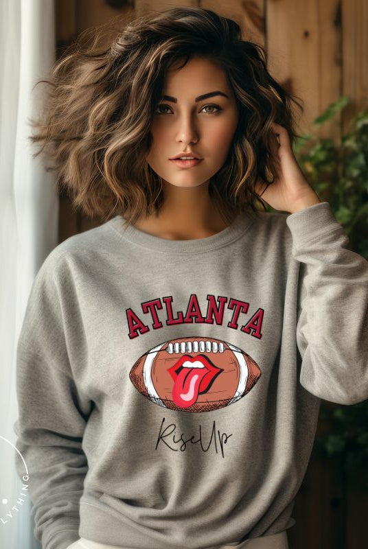 Show your Atlanta Falcons pride with our cozy and warm sweatshirt featuring the team's name and empowering slogan, "Rise Up." On a sports grey sweatshirt. 