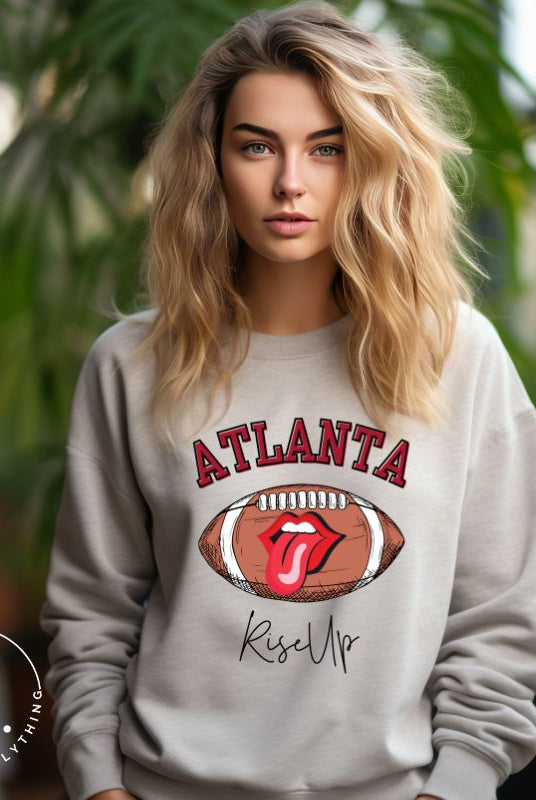 Show your Atlanta Falcons pride with our cozy and warm sweatshirt featuring the team's name and empowering slogan, "Rise Up." On a grey sweatshirt.