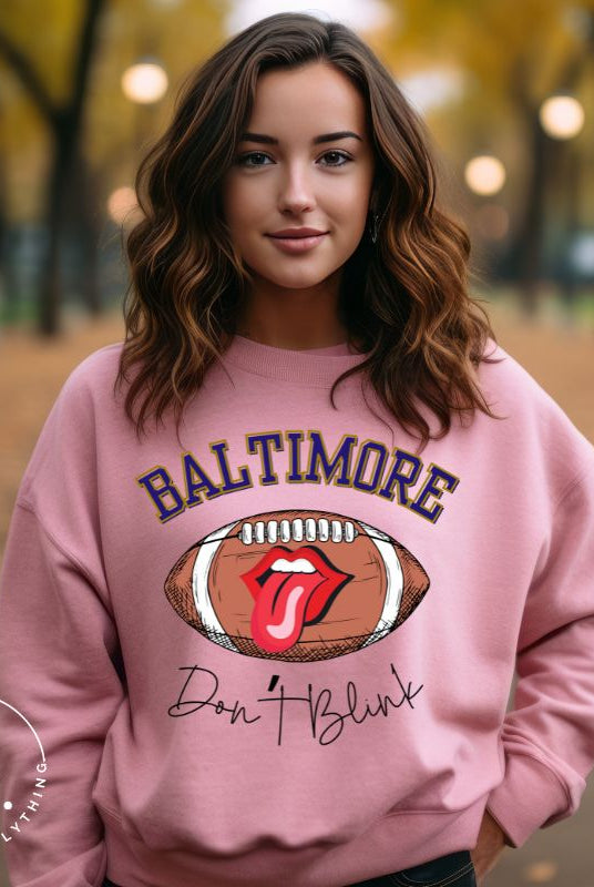 Embrace your Baltimore Ravens pride with our modern and trendy sweatshirt featuring the team's name and powerful slogan, "Don't Blink." On a pink sweatshirt. 