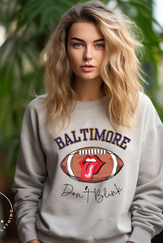 Embrace your Baltimore Ravens pride with our modern and trendy sweatshirt featuring the team's name and powerful slogan, "Don't Blink." On a grey sweatshirt. 