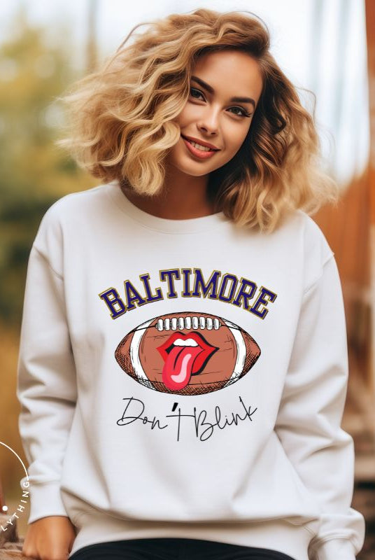 Embrace your Baltimore Ravens pride with our modern and trendy sweatshirt featuring the team's name and powerful slogan, "Don't Blink." On a white sweatshirt.
