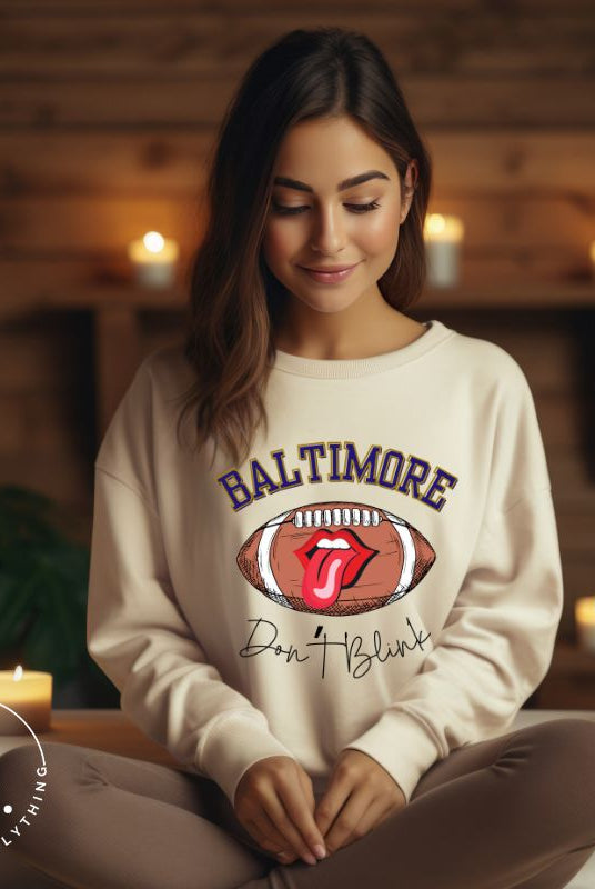 Embrace your Baltimore Ravens pride with our modern and trendy sweatshirt featuring the team's name and powerful slogan, "Don't Blink." On a sand colored sweatshirt. 