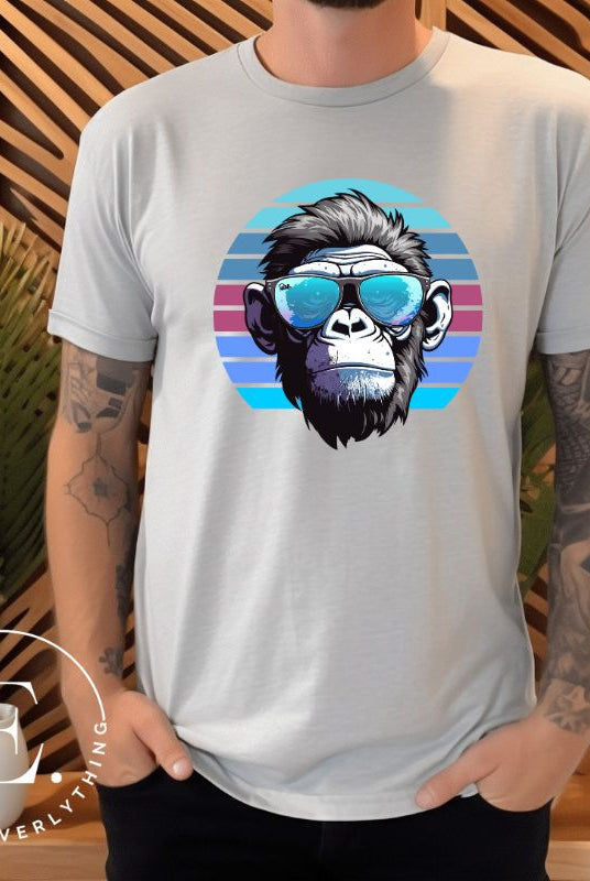 Hyper-realistic gorilla wearing sunglasses with a retro blue horizon behind on a ash colored shirt.