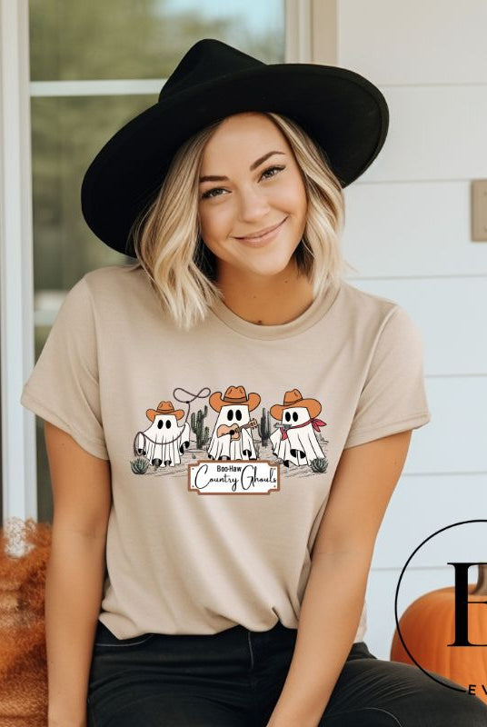 Boo-haw! Get ready for a hauntingly good time with our country ghost shirt. Featuring a spirited spectator donning cowboy hat, this shirt combines Halloween with country charm. The clever play on words, ' Country Ghouls,' adds a fun twist on a tan shirt.