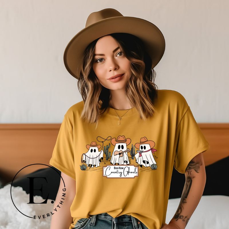 Get ready for a boot-stompin' Halloween with our country-themed PNG sublimation download. Featuring ghostly cowboys in cowboy hats, lassos, and playing country music, all accompanied by the catchy saying 'Boo-Haw Country Ghouls.' PNG example on a yellow shirt. 