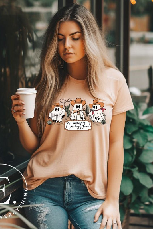 Boo-haw! Get ready for a hauntingly good time with our country ghost shirt. Featuring a spirited spectator donning cowboy hat, this shirt combines Halloween with country charm. The clever play on words, ' Country Ghouls,' adds a fun twist on a tan shirt. 