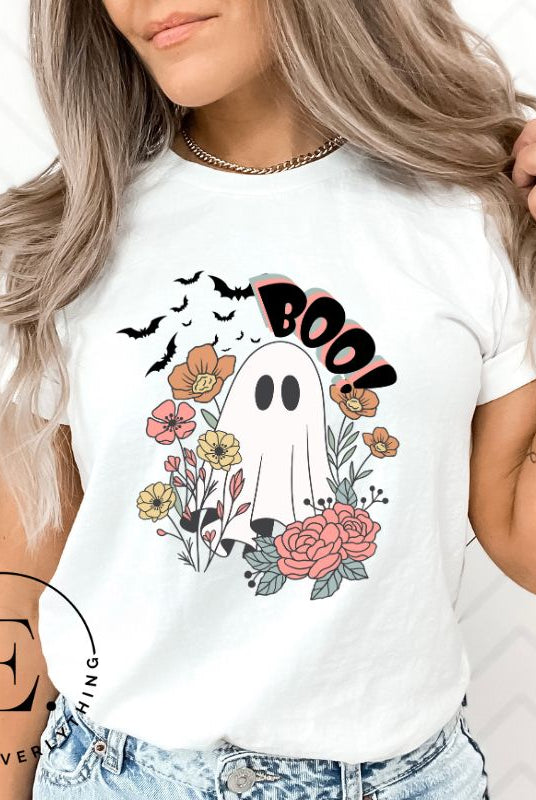 Get ready for Halloween with our cute and spooky ghost-themed shirt! Featuring a whimsical design with a cute ghost, flowers, and bats in a starry sky, it's the perfect blend of spooky and sweet on a white shirt. 