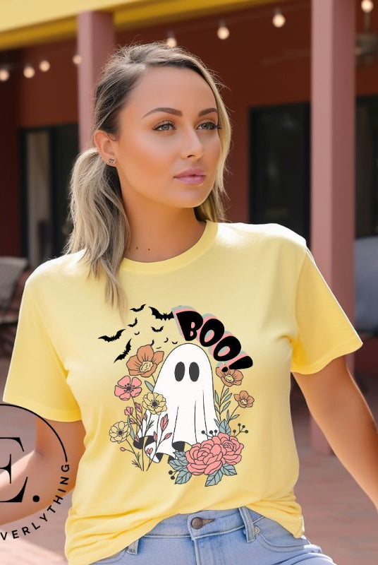 Get ready for Halloween with our cute and spooky ghost-themed shirt! Featuring a whimsical design with a cute ghost, flowers, and bats in a starry sky, it's the perfect blend of spooky and sweet on a yellow shirt. 