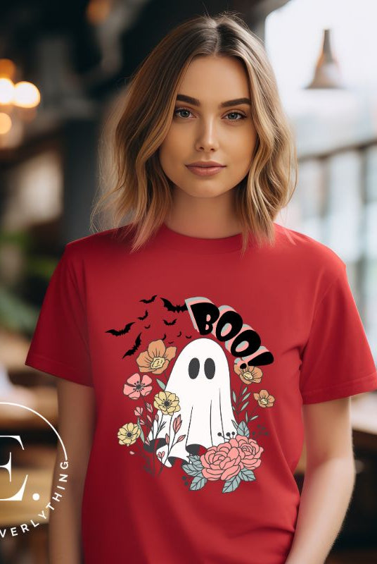 Get ready for Halloween with our cute and spooky ghost-themed shirt! Featuring a whimsical design with a cute ghost, flowers, and bats in a starry sky, it's the perfect blend of spooky and sweet on a red shirt. 