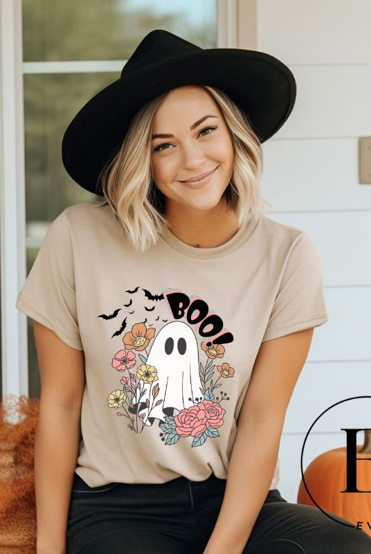 Get ready for Halloween with our cute and spooky ghost-themed shirt! Featuring a whimsical design with a cute ghost, flowers, and bats in a starry sky, it's the perfect blend of spooky and sweet on a tan shirt. 