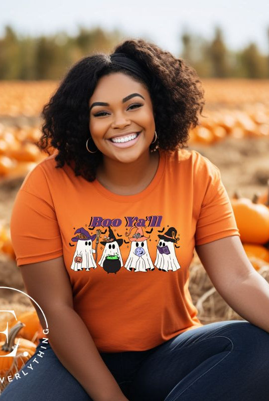 Get into the Halloween spirit with our adorable PNG sublimation download. Four cute ghost going trick-or-treating, accompanied by the playful saying 'Boo Ya'll.' PNG example on a orange shirt. 