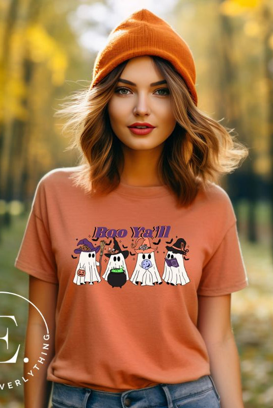 Get into the Halloween spirit with our adorable PNG sublimation download. Four cute ghost going trick-or-treating, accompanied by the playful saying 'Boo Ya'll.' PNG example on a peach shirt. 