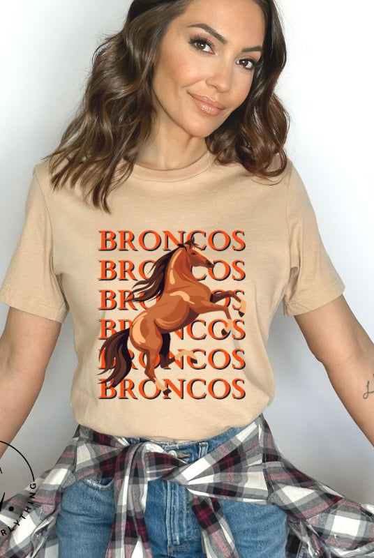 Saddle up for game day fun with our Bella Canvas 3001 unisex graphic tee! Gallop into Broncos spirit with our exclusive design featuring a lively Bronco horse and the spirited mantra "Broncos Broncos Broncos Broncos" on a tan shirt. 