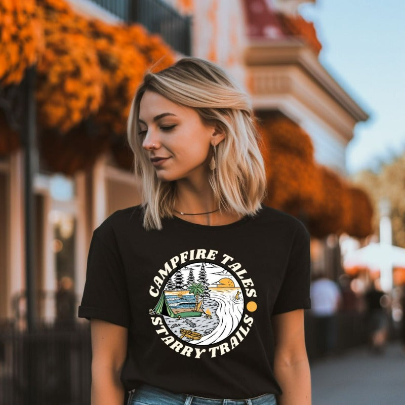 Black Bella + Canvas 3001 unisex t-shirt with a summer camping graphic design featuring a tent, campfire, and starry sky with the words 'Campfire Tales, Starry Trails' around the image.