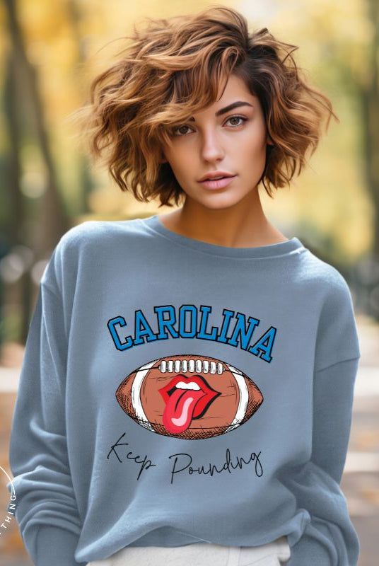 Support the Carolina Panthers in style with our modern and trendy sweatshirt featuring the team's name and powerful teams slogan, "Keep Pounding."  On a blue sweatshirt. 