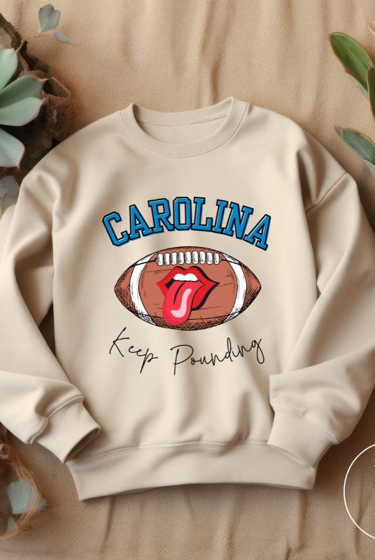 Support the Carolina Panthers in style with our modern and trendy sweatshirt featuring the team's name and powerful teams slogan, "Keep Pounding."  On a sand colored sweatshirt. 
