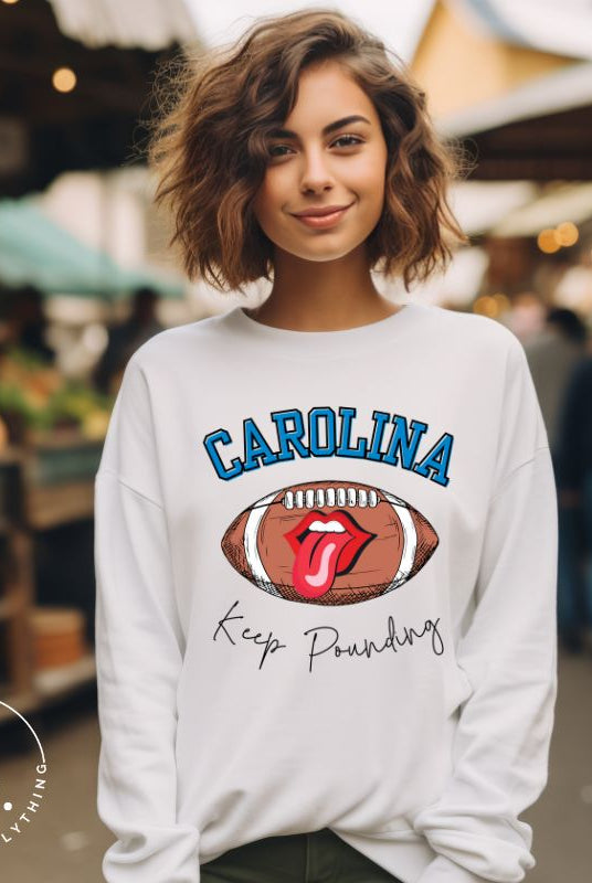 Support the Carolina Panthers in style with our modern and trendy sweatshirt featuring the team's name and powerful teams slogan, "Keep Pounding." On a white sweatshirt. 