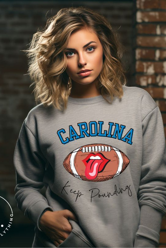 Support the Carolina Panthers in style with our modern and trendy sweatshirt featuring the team's name and powerful teams slogan, "Keep Pounding." On a grey sweatshirt. 