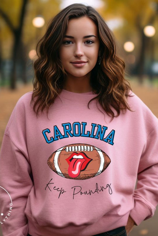 Support the Carolina Panthers in style with our modern and trendy sweatshirt featuring the team's name and powerful teams slogan, "Keep Pounding."  On a pink sweatshirt. 