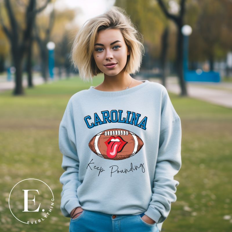 Support the Carolina Panthers in style with our modern and trendy sweatshirt featuring the team's name and powerful teams slogan, "Keep Pounding."  On a blue sweatshirt. 