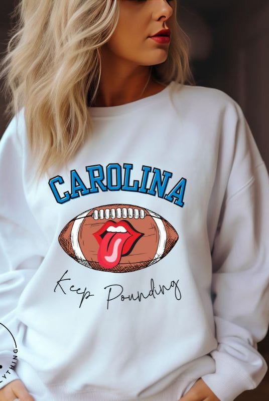 Support the Carolina Panthers in style with our modern and trendy sweatshirt featuring the team's name and powerful teams slogan, "Keep Pounding."  On a white sweatshirt. 