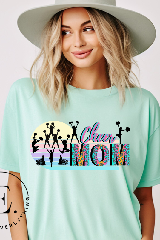 Get your cheer on with our stylish cheer mom shirt. Perfect for proud moms supporting their cheering stars. Made with love, this shirt combines comfort and fashion, letting you show off your team spirit. Join the cheer squad and cheer your heart out in style on a mint shirt. 