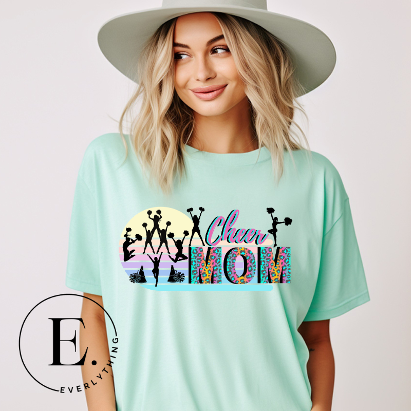 Get your cheer on with our stylish cheer mom shirt. Perfect for proud moms supporting their cheering stars. Made with love, this shirt combines comfort and fashion, letting you show off your team spirit. Join the cheer squad and cheer your heart out in style on a mint shirt. 