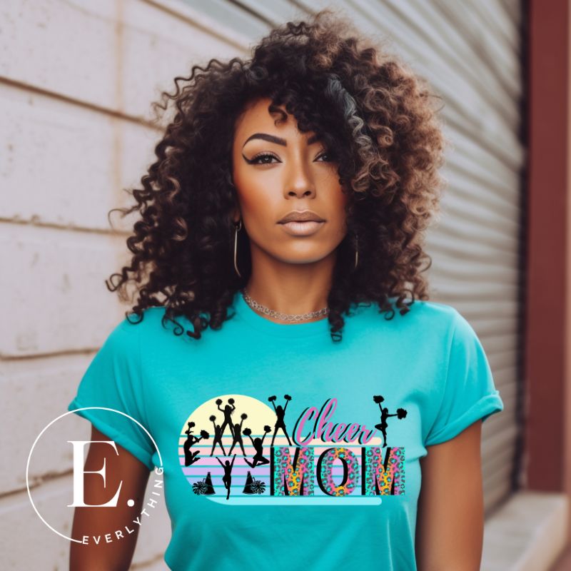 Get your cheer on with our stylish cheer mom shirt. Perfect for proud moms supporting their cheering stars. Made with love, this shirt combines comfort and fashion, letting you show off your team spirit. Join the cheer squad and cheer your heart out in style on a teal shirt. 