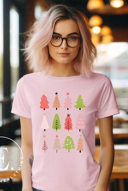 Upgrade your holiday fashion with our contemporary Christmas shirt. The shirt features three rows of multiple different modern Christmas trees in each row, creating a trendy and charming design on a pink shirt. 