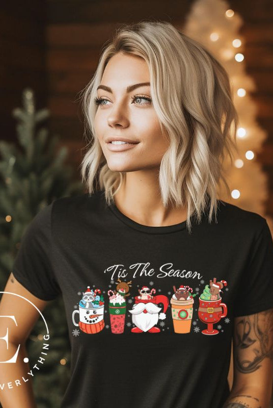 Wrap yourself in cozy holiday vibes with our Christmas coffee cup shirt. With a festive design that says "Tis The Season," this shirt captures the essence of warmth and joy on this black colored shirt.