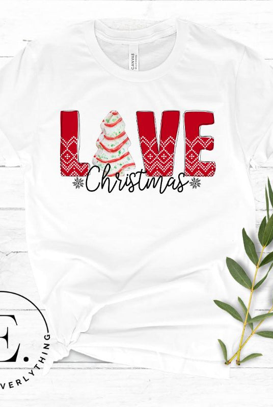 Spread love and joy this holiday season with our Christmas shirt featuring the classic Christmas tree cake, which is incorporated into the word "Love" on a white colored shirt.