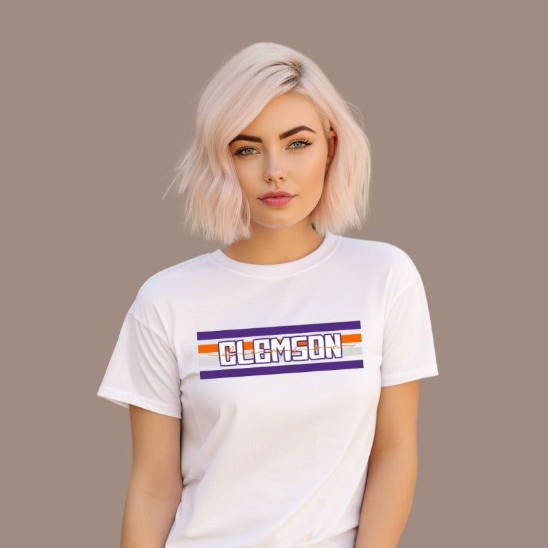 Bella + Canvas 3001 unisex shirt with Clemson University stripe design in purple, orange, and white, with "Clemson" written in bold letters on a white graphic tee.