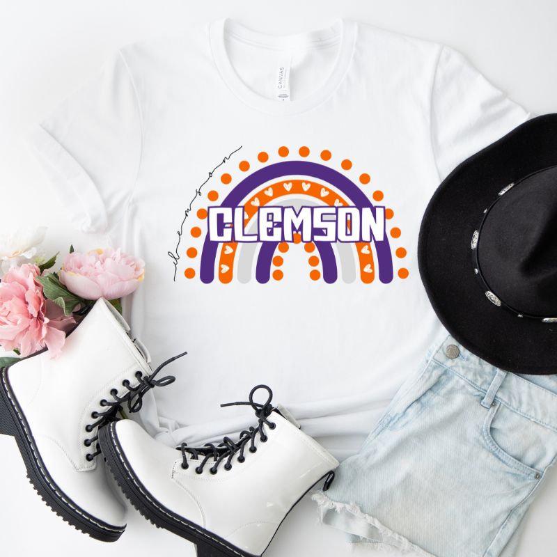 Bella + Canvas 3001 unisex shirt featuring a colorful rainbow design with the word "Clemson" in the center, representing Clemson University on a white graphic tee.